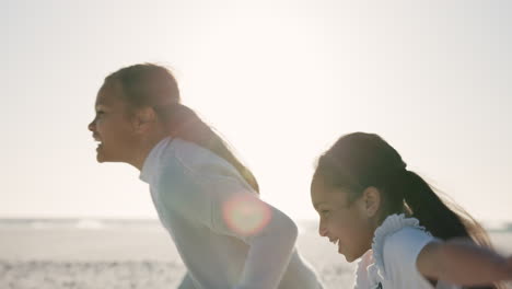 Girl-siblings,-holding-hands-and-running-on-beach