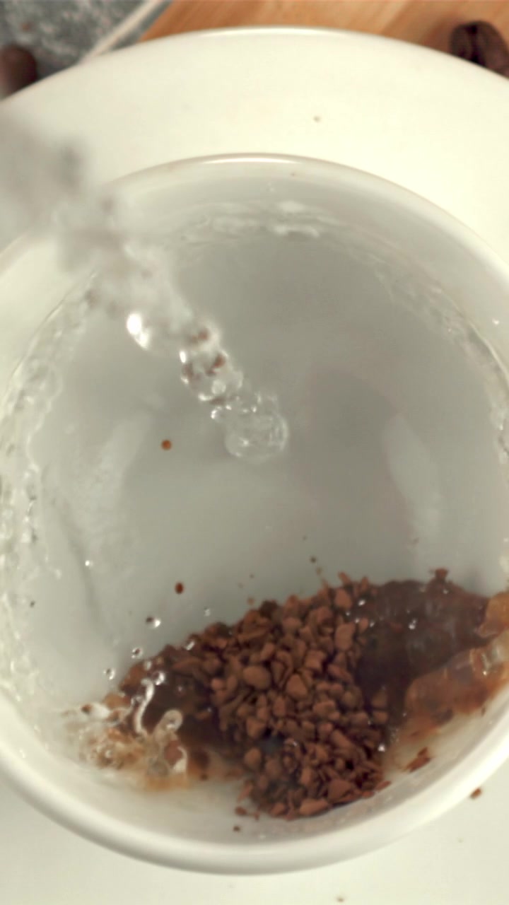 Primo piano di acqua calda versata su granuli di caffè istantaneo
