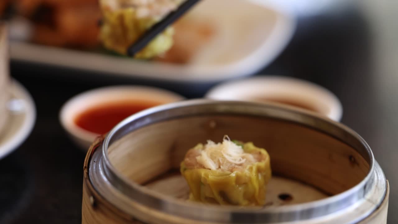 palillos para comer recogiendo albóndigas de un vapor de bambú