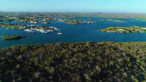 Catamaran-floats-calmly-in-spanish-waters-curacao-at-sunrise,-beautiful-blue-sky-day