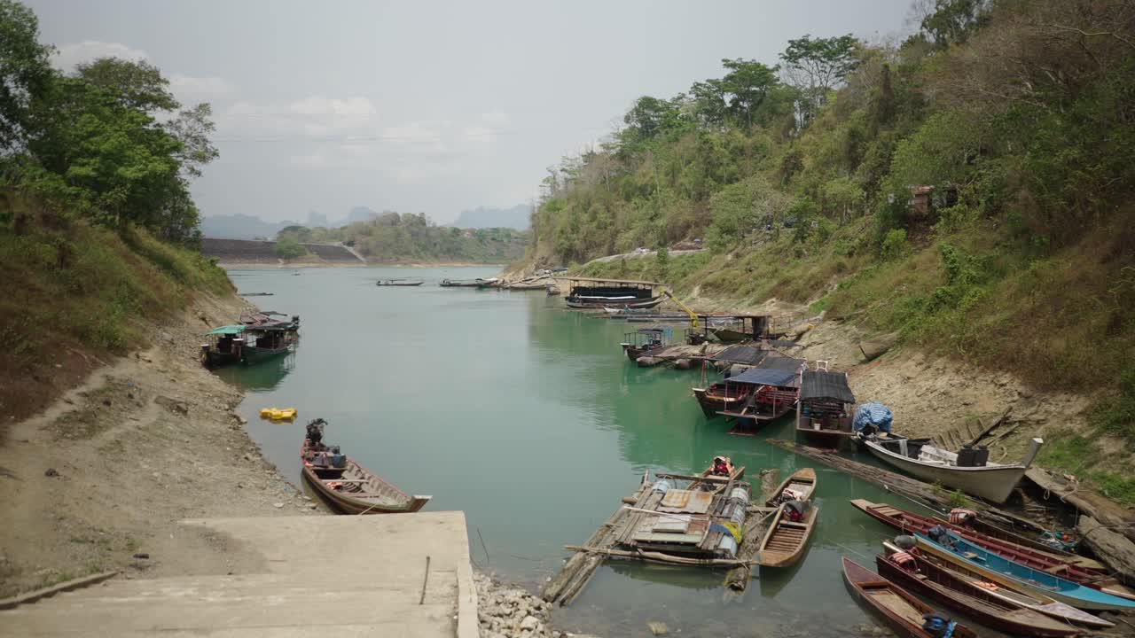 Traditional Boats and Houseboats Moored Along a River Bank