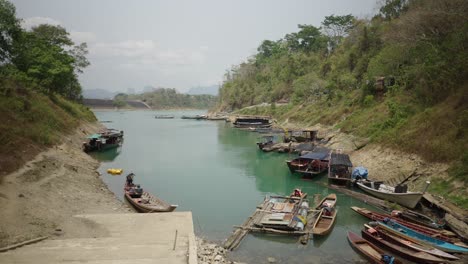 traditional boats and houseboats moored along a river bank