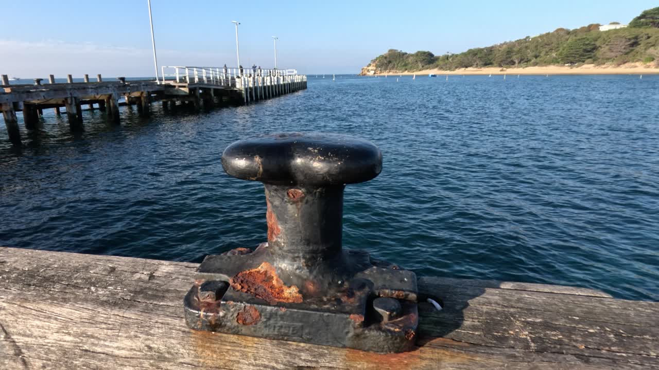 Rusty mooring on pier overlooking calm bay