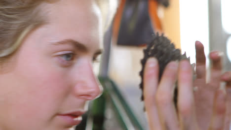 -Woman-repairing-parts-of-bicycle-at-workshop-4k