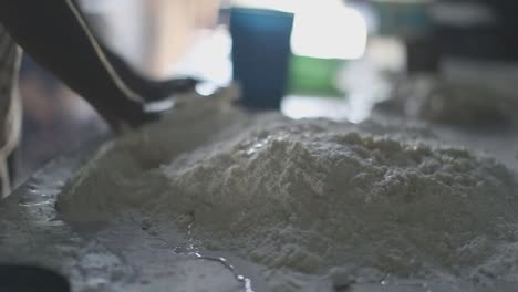 hands mixing a pile of flour dough