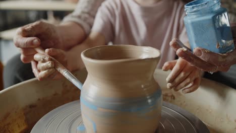 grandmother teaches her granddaughter working on a pottery rotating wheel