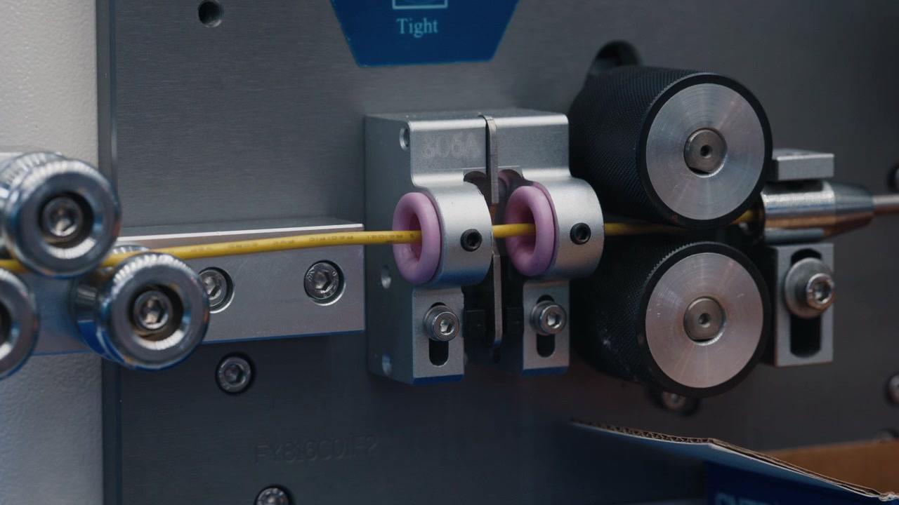Industrial Wire Processing Machine Feeding Yellow Cable Through Rollers