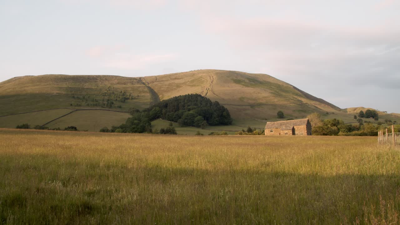 구불구불한 언덕과 푸른 하늘이 있는 그림 같은 영국 시골의 패닝 샷