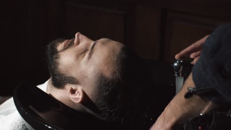 man getting hair washed at a barbershop