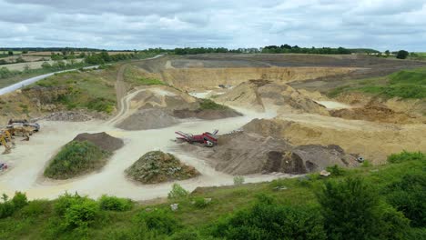 drone descent over mineral extraction pits, shovels, and heavy vehicles near grantham