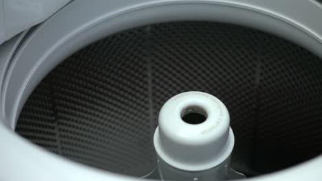 man put dirty clothes in laundry machine