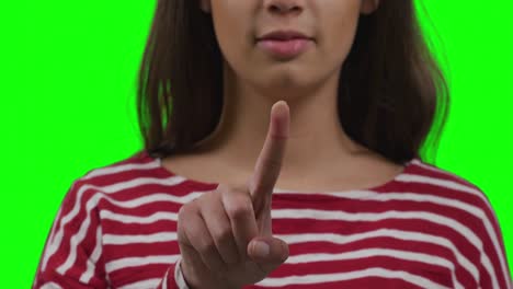 mujer caucásica señalando sobre un fondo verde