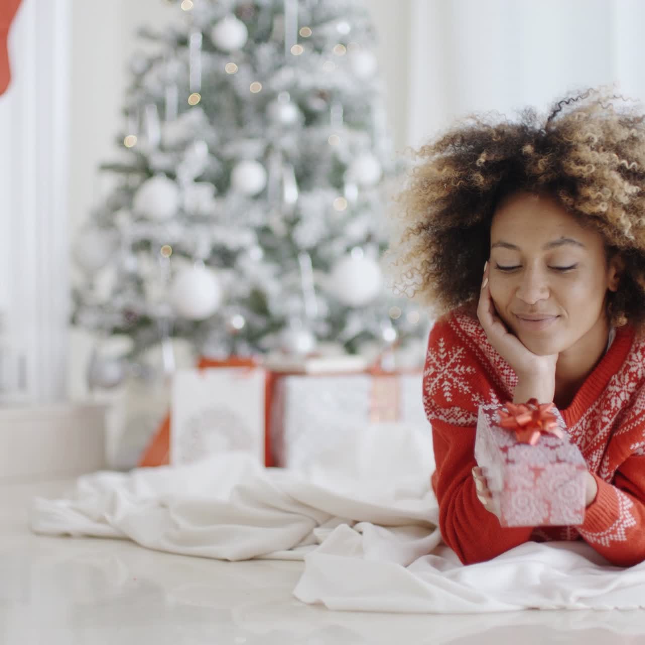 niña tumbada mirando su regalo de navidad