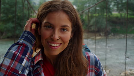 Smiling-girl-looking-camera-on-mountains-forest.-Happy-woman-enjoy-nature-view.