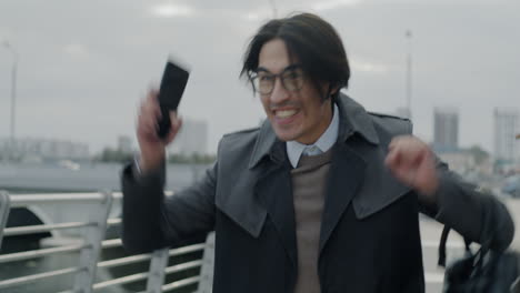 happy businessman celebrating on mobile phone