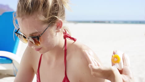 teenage girlfriends helping each other putting on sunscreen on back for skin care protection