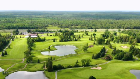 drone flying over a golf course with dense forest in the distance