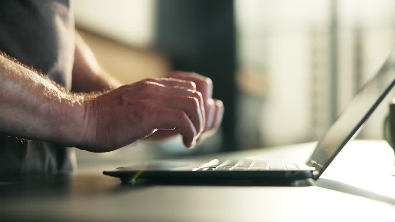 Close Up of Man's Hands Typing on Laptop Keyboard