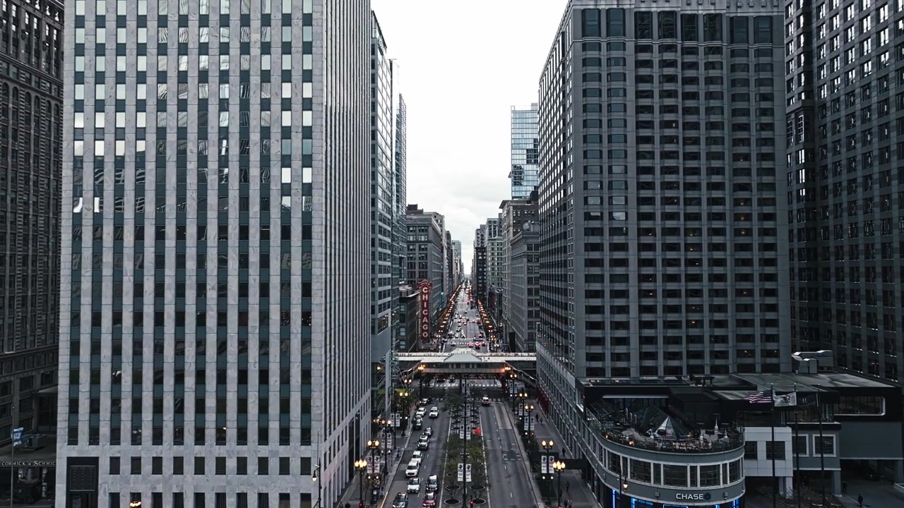 Vista aerea con panoramica a sinistra sopra una strada di Chicago, circondata da grattacieli e dall'energia metropolitana.