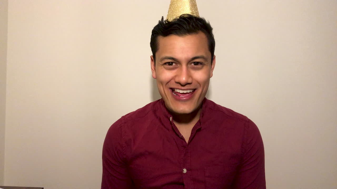 joven en videollamada cuenta regresiva para año nuevo y celebrando con party popper