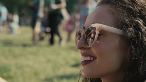 primer plano de una mujer caucásica bebiendo cerveza de una taza desechable en un festival de música.