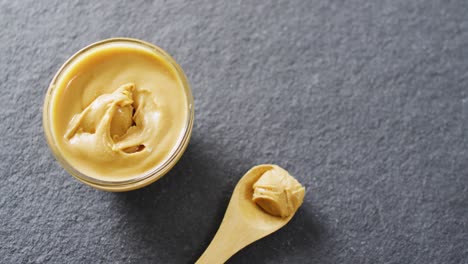 Video-of-close-up-of-peanut-butter-on-gray-background