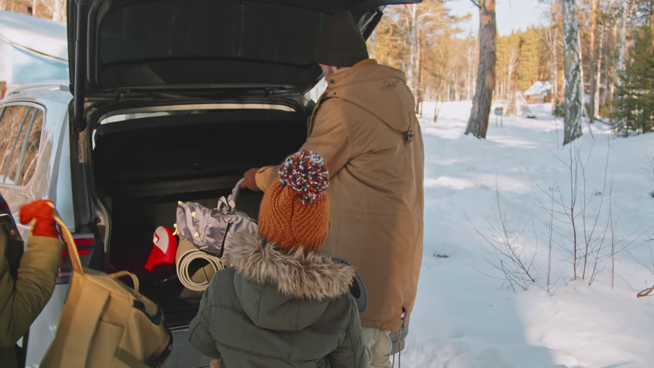 Family Unloading Car on Winter Day