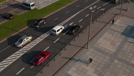 Tracking-of-cars-driving-in-streets-of-town-at-golden-hour.-Tilt-down-focusing-of-red-sports-car.-Warsaw,-Poland