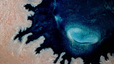 swirling blue and sandy substances mixing in a vibrant and dynamic macro shot