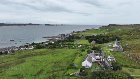 aerial view of iona island, scotland uk, green landscape and waterfront homes, drone shot 60fps