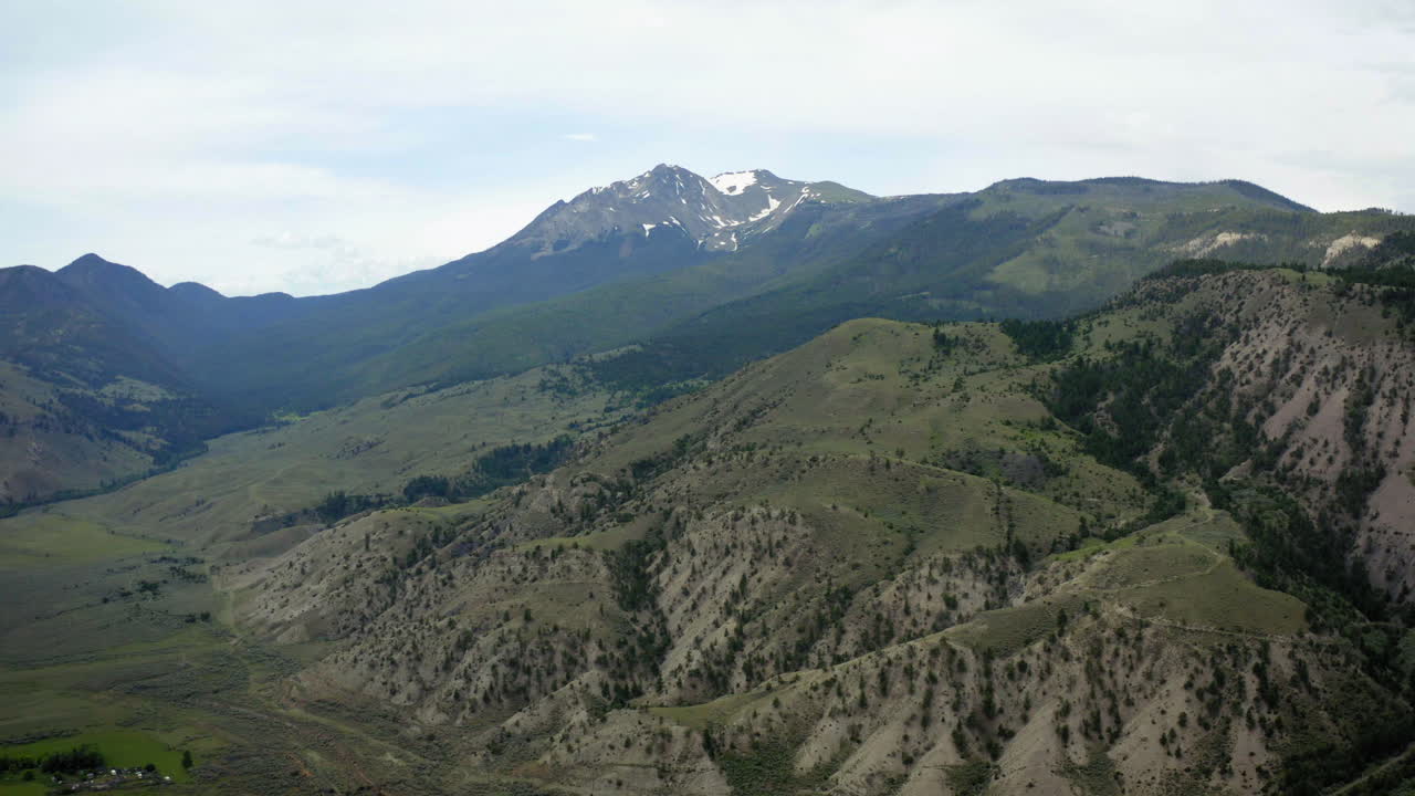 Panoramic view of a mountain valley with peaks and forested slopes