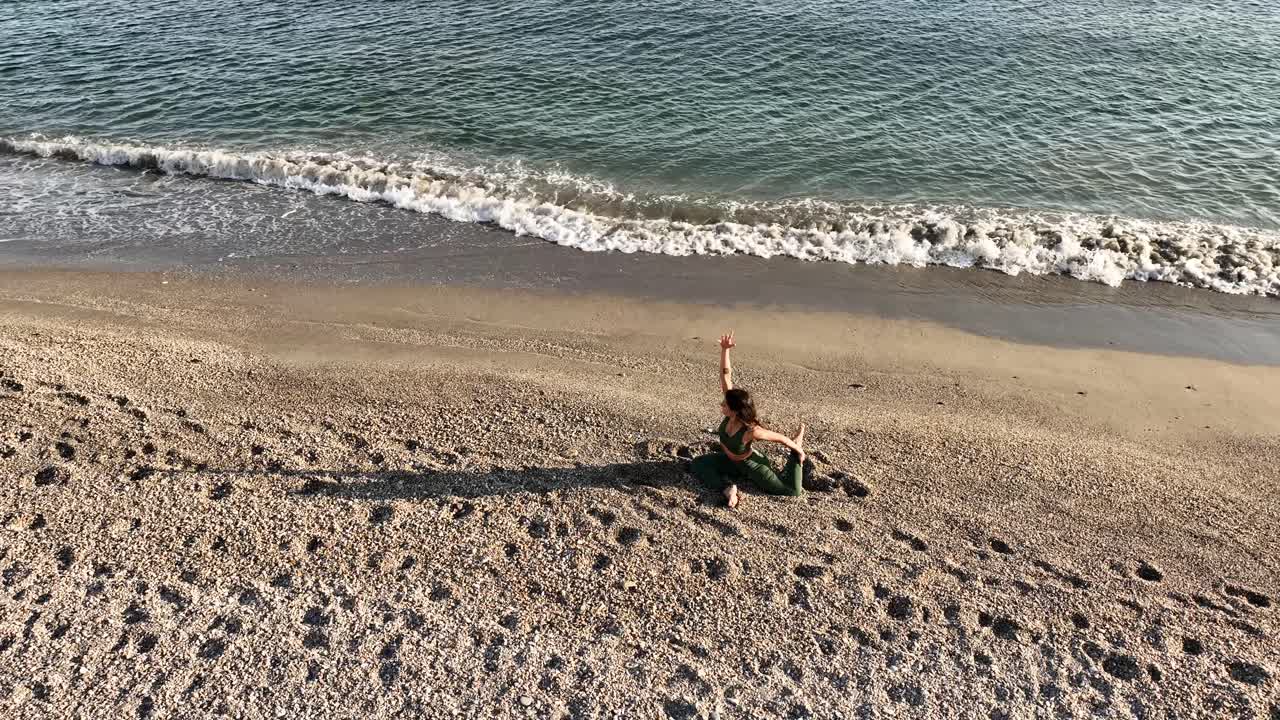 Woman performing yoga pose on sandy beach