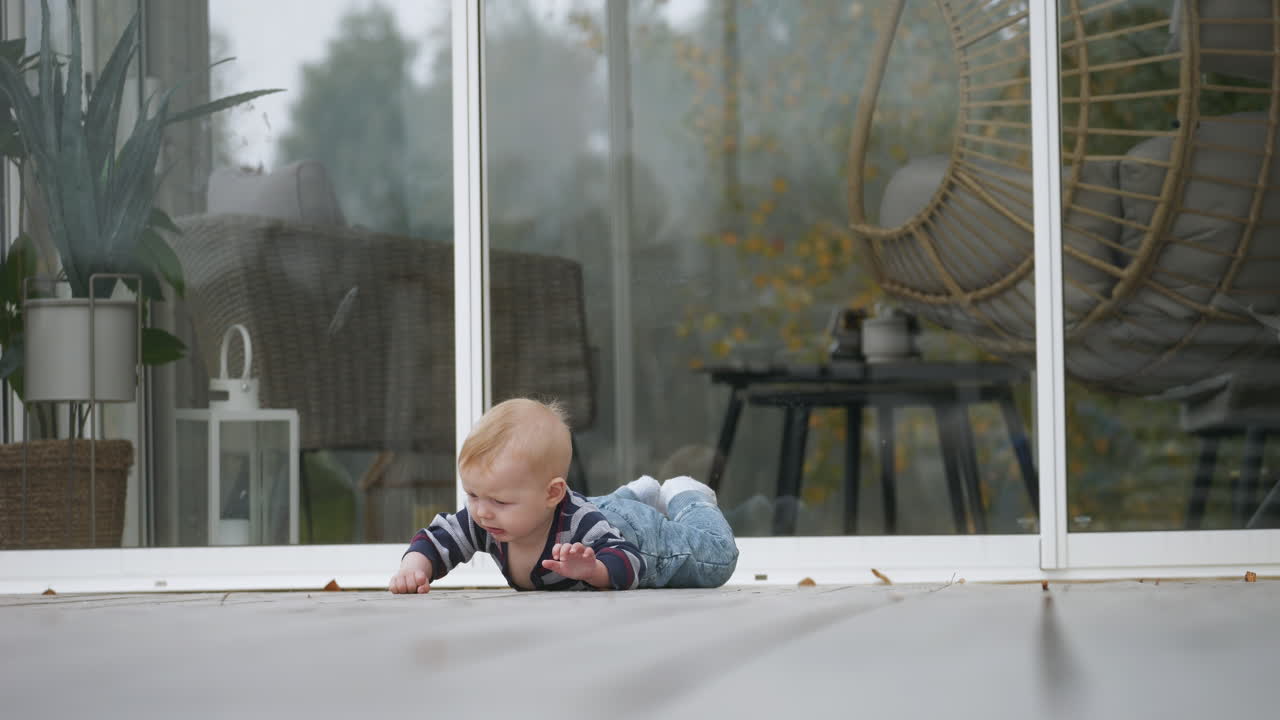 Helpless caucasian baby toddler falling in the backyard, slow motion