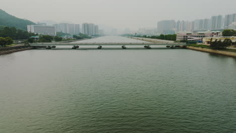 drone panning backward over a large river on a foggy day