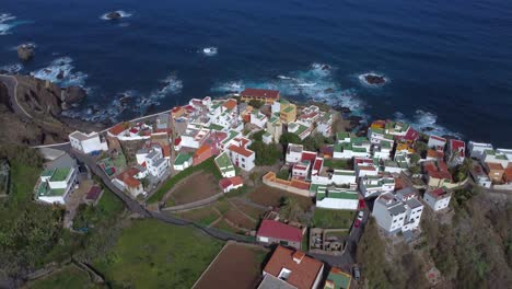 a drone video of a colourful coastal village next to the sea, in tenerife benijo