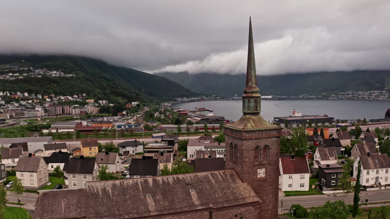 Aerial drone shot over the city of Narvik in Norway. High view of the local church, houses and buildings of the nordic town.