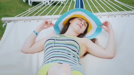 una joven atractiva está tomando el sol en una hamaca. mujer en el concepto