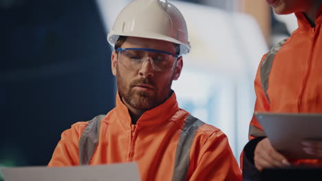 plant workers checking technical documents on manufacture facility close up.