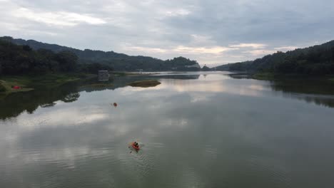 Asiaten,-Die-Morgens-Auf-Einem-Stausee-Mit-Einer-Schönen-Aussicht-Kanufahren