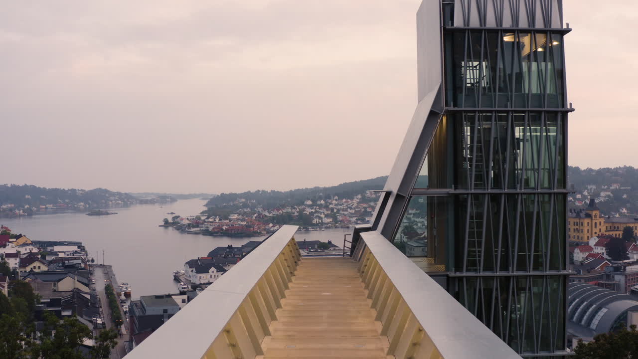 volando sobre el punto de vista vacío hacia el ascensor de vidrio con vistas a las casas de la ciudad de arendal y la iglesia en noruega