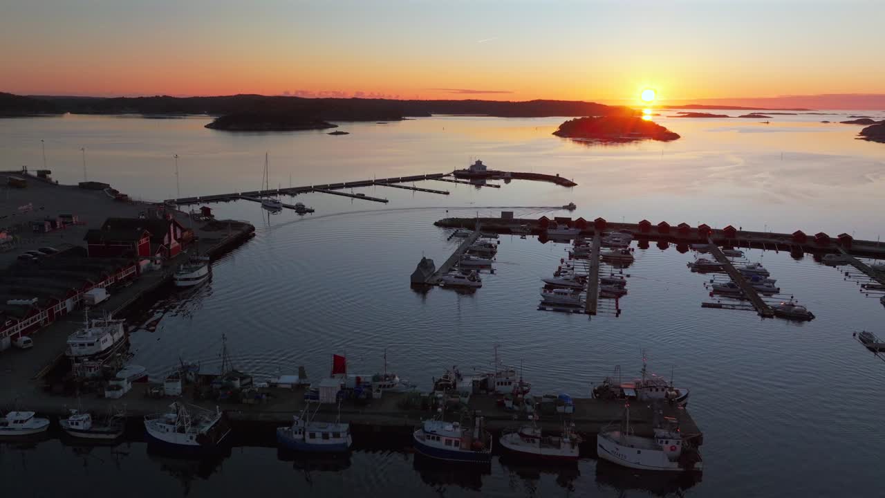 Strömstad Stromstad Sweden aerial drone boat trolling arctic golden sunset sun on horizon Sandelfjord Fjord Baltic Sea Seaside Town marina harbor picturesque Koster islands Oscarspromenaden forward