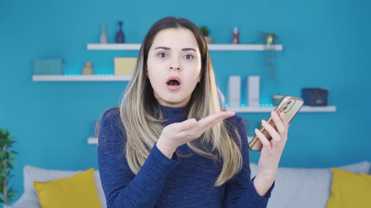 joven sorprendida y asombrada por lo que ve en el teléfono.