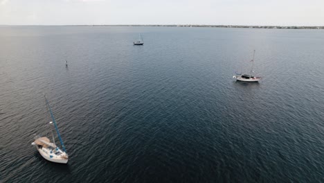 Luftaufnahme,-Die-über-Segelboote-In-Einer-Lagune-Mit-Blauem-Wasser-Fliegt