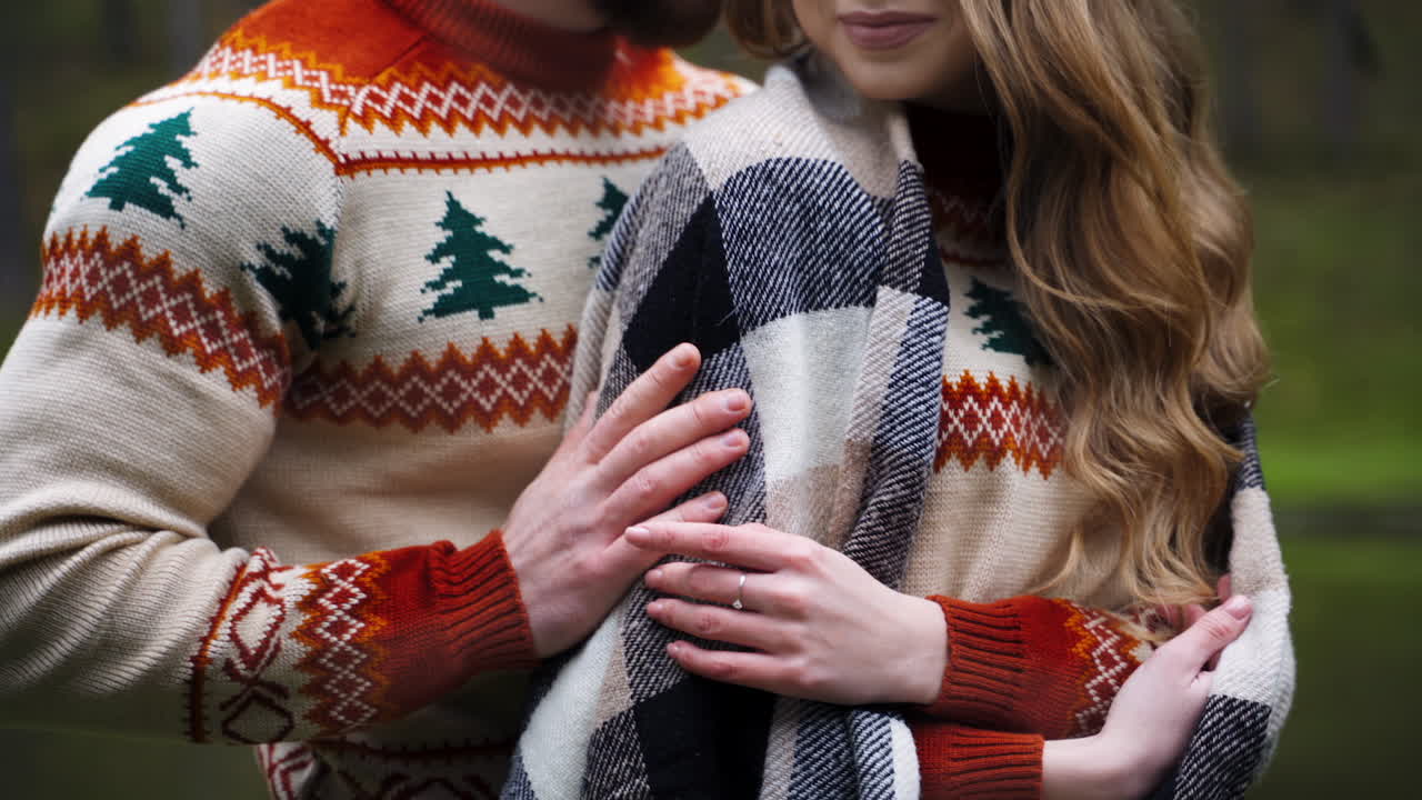 Lovely couple. Happy couple at romantic date outdoors. Young man and woman in warm same sweaters. Guy hugging girlfriend. Close-up.
