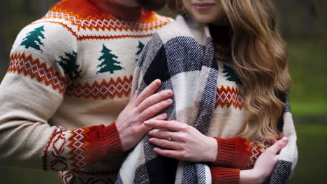 lovely couple. happy couple at romantic date outdoors. young man and woman in warm same sweaters. guy hugging girlfriend. close-up.
