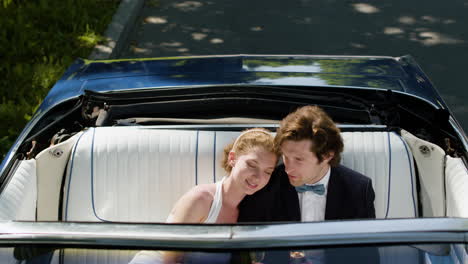 just married couple in a blue convertible car