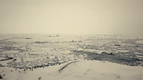 Filmische-Drohnenbewegungen-Zeigen-Einen-Schwarzen-Sandstrand-In-Island,-Der-Von-Einer-Drohne-Bei-Schnee-Gefilmt-Wurde