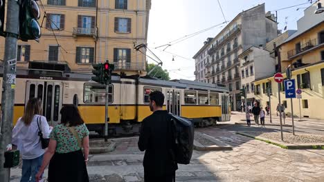 people waiting as tram passes by