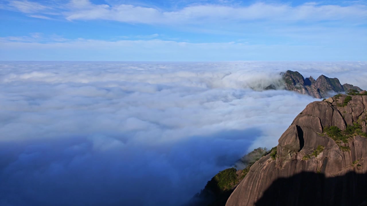 Filmagem em time-lapse do nascer do sol sobre um mar de nuvens na Montanha Huangshan. Cenário natural aéreo dos picos rochosos de Huangshan cercados por névoa ondulante.