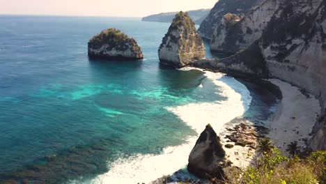beautiful 4k tropical beach aerial - a bird's eye view of ocean waves crashing against an empty beach from above.